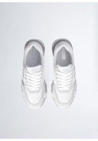 Bílé sportovní boty s mesh a syntetickým materiálem, zaoblenou špičkou, lehkým designem a šedými akcenty na podrážce a značce.