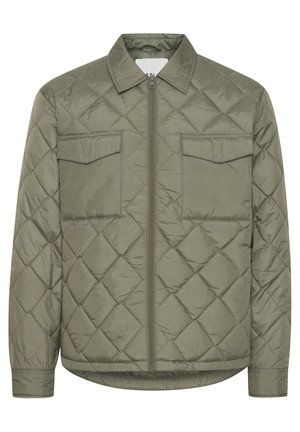 Pats anovējs olīvu zaļas krāsas jakai ar divām krūšu kabatām, rāvējslēdzēja priekšpusi un apkakli. Viegls, ar gludu, spīdīgu tekstūru.