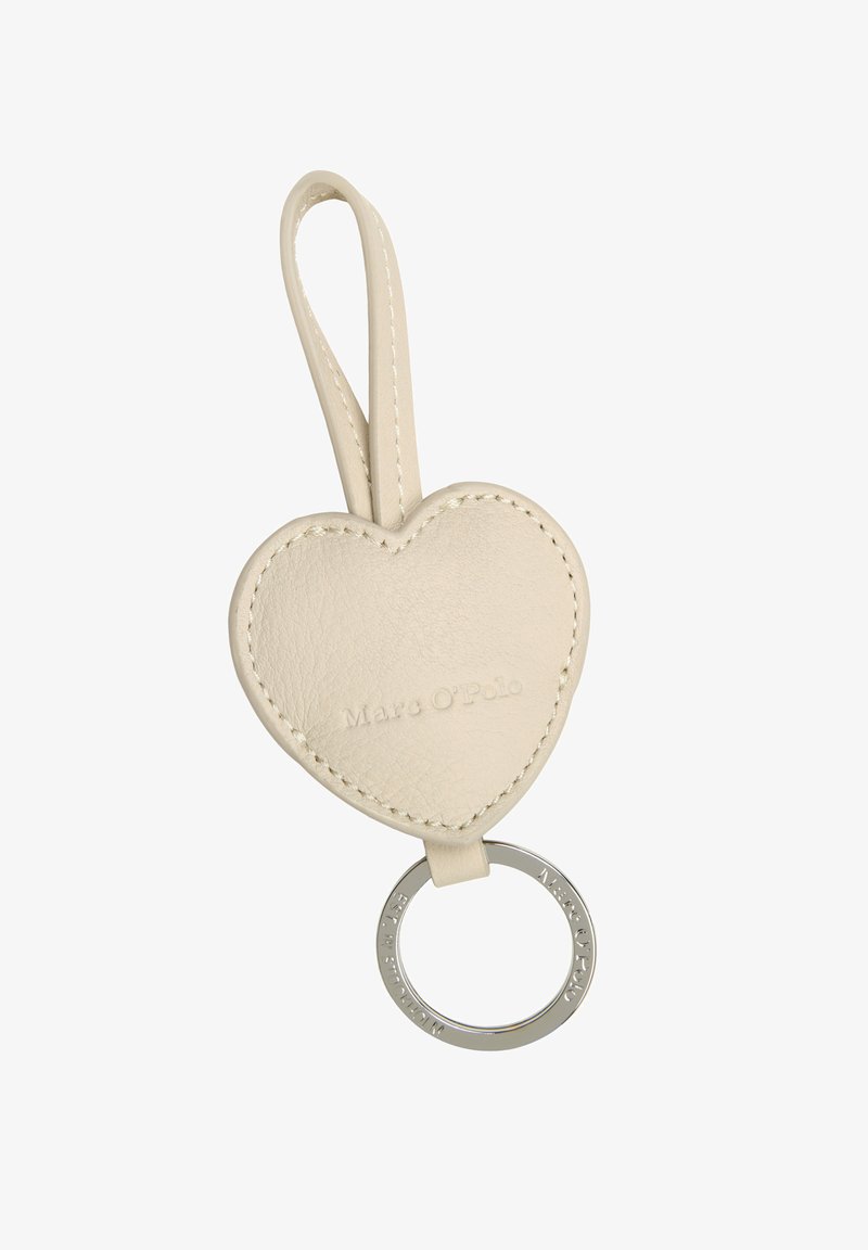 Brelok w kształcie serca z kremowej skóry, z przeszytymi krawędziami, wytłoczonym logo i okrągłym metalowym pierścieniem w kolorze srebrnym.