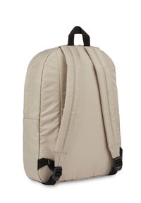 Mochila de nylon bege com alças pretas ajustáveis, uma pega na parte superior e uma textura suave; apresenta bolsos laterais e um design minimalista.