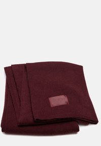 Sciarpa knit color bordeaux realizzata in tessuto morbido con una superficie liscia, dotata di una piccola etichetta in pelle con testo in rilievo su un lato.