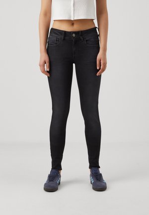 Jeans skinny negros con una cintura de altura media, que presentan un diseño clásico de cinco bolsillos, costuras sutiles y una textura de denim suave.