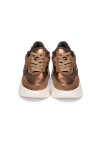Zapatillas de color bronce con materiales lisos y texturizados, que cuentan con cordones beige y una suela blanca gruesa. Acabadas con un diseño estampado.