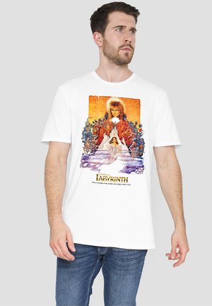 White T-shirt featuring a colorful graphic print from "Labyrinth," showcasing characters and intricate designs with vibrant orange, purple, and blue tones.