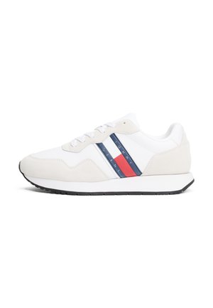 Zapatillas deportivas blancas y beige con cuero liso y ante. Presentan rayas azules y rojas, cordones blancos y una suela de goma texturizada.