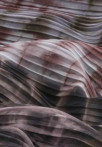 Transparent, texturerad tyg med växelvis mörka och ljusa ränder, som kännetecknas av ett nätliknande väv och mjukt fall.
