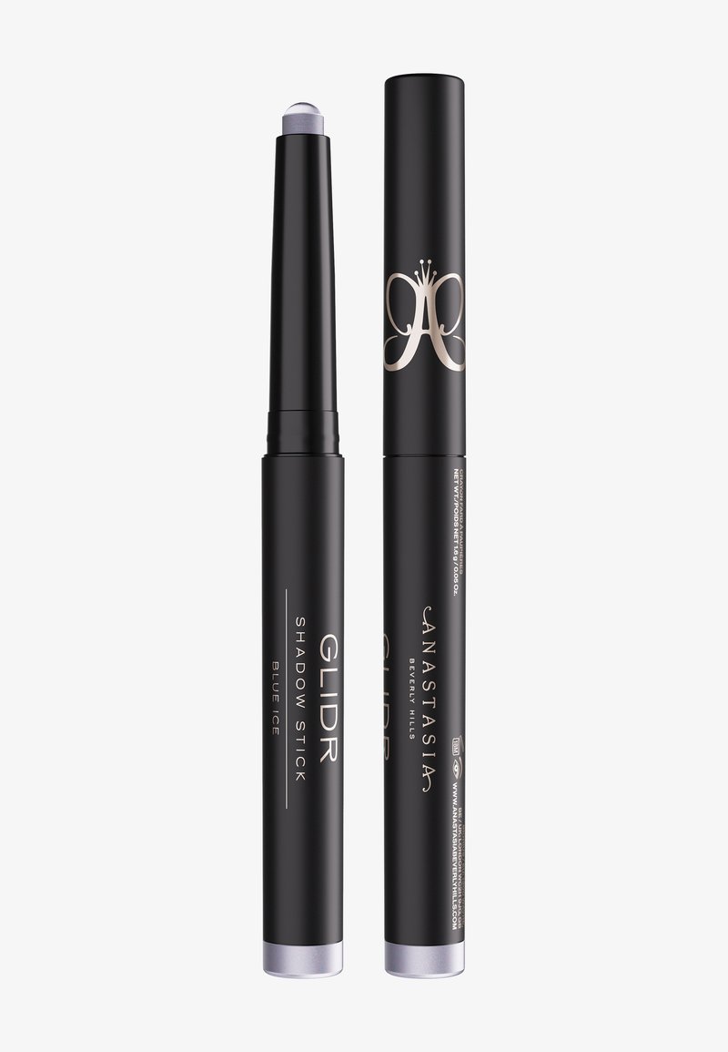 Deux crayons de maquillage noirs, l'un sans capuchon révélant une pointe d'ombre à paupières bleu clair scintillant, étiqueté "GLIDR Shadow Stick Blue Ice", marque Anastasia.