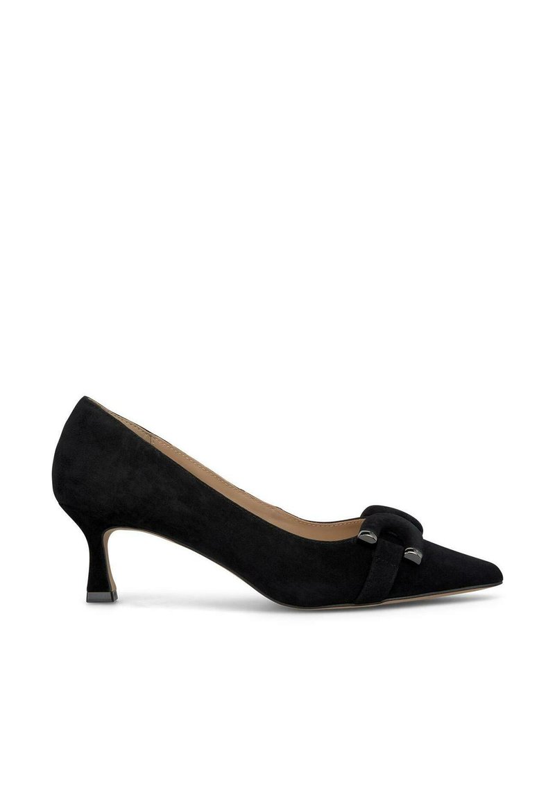 Zapato de tacón alto de ante negro con punta afilada, tacón pequeño y un acento decorativo de nudo en la parte delantera. Textura suave en todo.