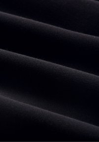 Tissu noir avec une texture lisse, comportant de douces plis et un léger éclat, affichant une couleur uniforme sans motifs visibles ni accessoires.