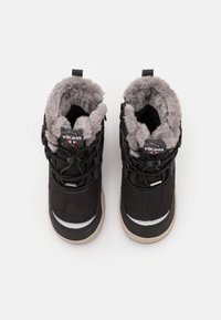 Botas de invierno negras con forro de piel sintética gris, punta redonda y suela de goma. Presentan cordones elásticos y un parche con el logo en la lengüeta.