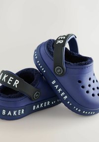 Mornarsko plave klompe s mekanim, plišastim oblogom, s istaknutim ventilacijskim otvorima, crnim podešavanim remenom i oznakom "BAKER by TED BAKER".
