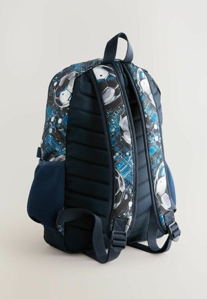 Rygsæk med polstret struktur og design i blå og sort med fodboldtema, meshniche på siden og justerbare stropper. Holdbart stof, sportsgrafik.