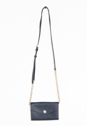 Small black leather crossbody bag with gold chain accents and adjustable leather strap, secured with a front button clasp.