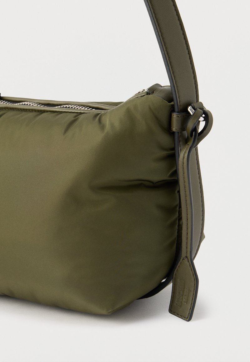 Olive green padded fabric handbag with a smooth finish, silver zipper, and adjustable leather shoulder strap with stitching details.