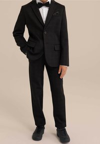 Černý kostkovaný oblek s jednobotónovým sakem, odpovídajícími kalhotami a bílou košilí. Zahrnuje černý motýlek a kapesníčkovou čtverec. Černé tenisky.