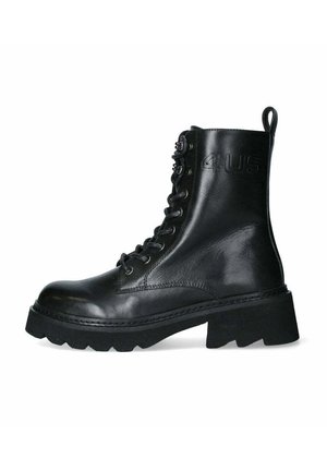 Stivale alla caviglia in pelle nera con suola alta e robusta, lacci davanti e linguetta posteriore. Presenta un marchio impressa sul lato e accessori in metallo.