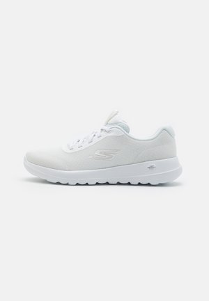 Hvid lavtop atletisk sneaker med tekstureret stofoverdel, snørelukning, polstret krave og mærke på sål og sideslogo på ensartet baggrund.