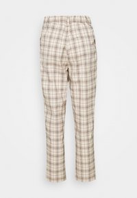 Pantalon à carreaux beige avec une taille élastique et des poches arrière, présenté de dos sur un fond uni.
