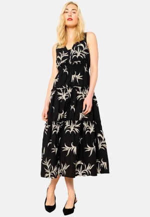 Schwarzes, gestuftes Maxikleid mit weißen floralen Mustern. Verfügt über einen V-Ausschnitt und einen elastischen Bund, hergestellt aus leichtem Stoff.