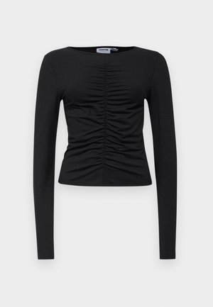 Must have musta pikkade varrukatega topp, mis on valmistatud venivast kangast, esiosa kokku volditud disainiga, ümmarguse kaelusega ja kehaümber oleva lõikega.