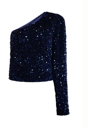 Üks õlg sinine sädelusega pika varrukaga top, millel on sobiv siluett ja särav tekstuur.