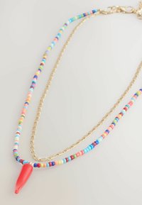 Buntes Perlenkette mit goldenen Kettengliedern, mehrfarbigen Perlen und einem roten Anhänger. Die Perlen haben unterschiedliche Größen und Designs.