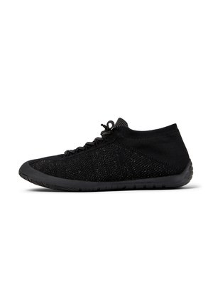 Black athletic shoes with a stretchy upper and flexible sole, featuring laces and a low-profile design for comfort and agility.