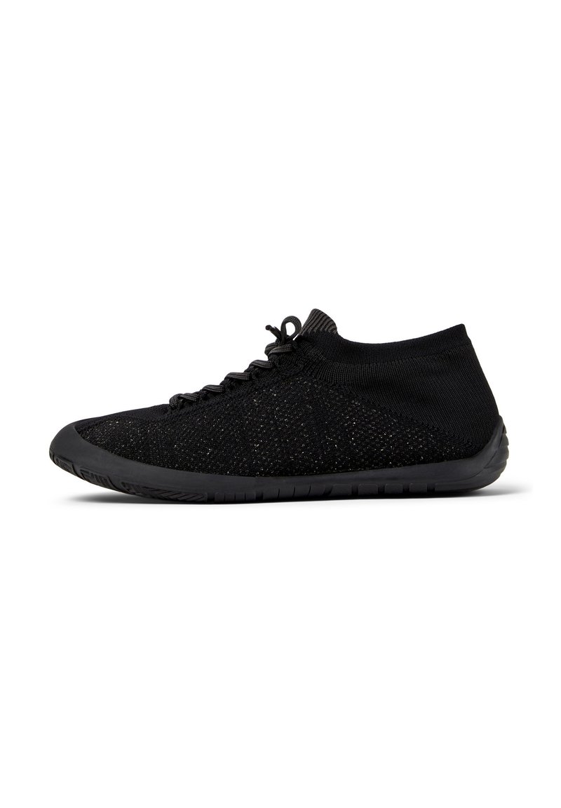 Baskets de sport noires avec une tige extensible et une semelle flexible, dotées de lacets et d'un design bas pour un confort et une agilité optimaux.