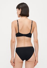 Zwart bh en bijpassend hoge taille ondergoed set. Gemaakt van soepel materiaal, met verstelbare banden en kanten afwerking.