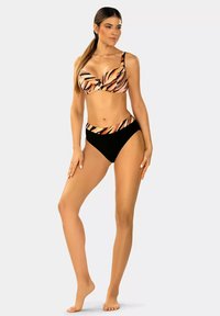 Czarny i pomarańczowy kostium kąpielowy w paski, zawierający wzorzysty top bralet z fiszbinami i wysokimi majtkami. Gładka tekstura materiału.
