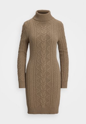 Brown cable-knit turtleneck sweater dress with long sleeves and intricate knit patterns on front and sleeves.