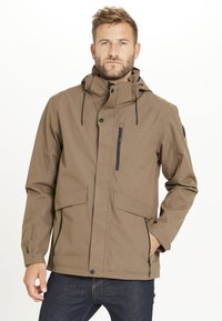 Brun vattentät jacka med huva, två framfickor, ficka på bröstet med dragkedja och justerbara dragsnören. Slät yta och minimalistisk design.