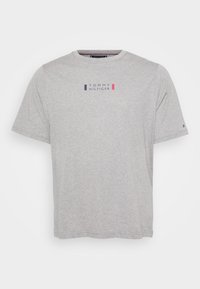 Szara bawełniana koszulka z krótkim rękawem i okrągłym dekoltem. Posiada małe, centralnie umieszczone logo z niebieskimi i czerwonymi akcentami. Miękka tekstura, luźny krój.