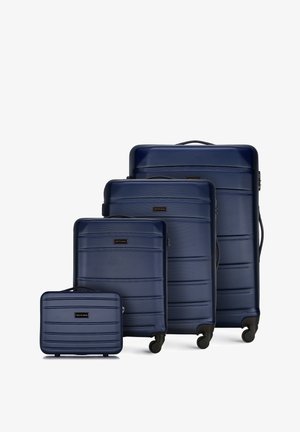 Set di quattro valigie rigide blu navy con superficie testurizzata, chiusure a zip e ruote scorrevoli in varie dimensioni.