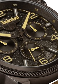 Orologio Timberland con quadrante esagonale scuro e texture, dettagli gialli, tre contatori e cassa in acciaio inox con lunetta texturizzata.
