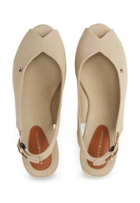 Béžové plátěné baleríny s křížovým designem, kulatou špičkou, koženou vložkou a malou zlatou sponou na řemínku kolem kotníku.