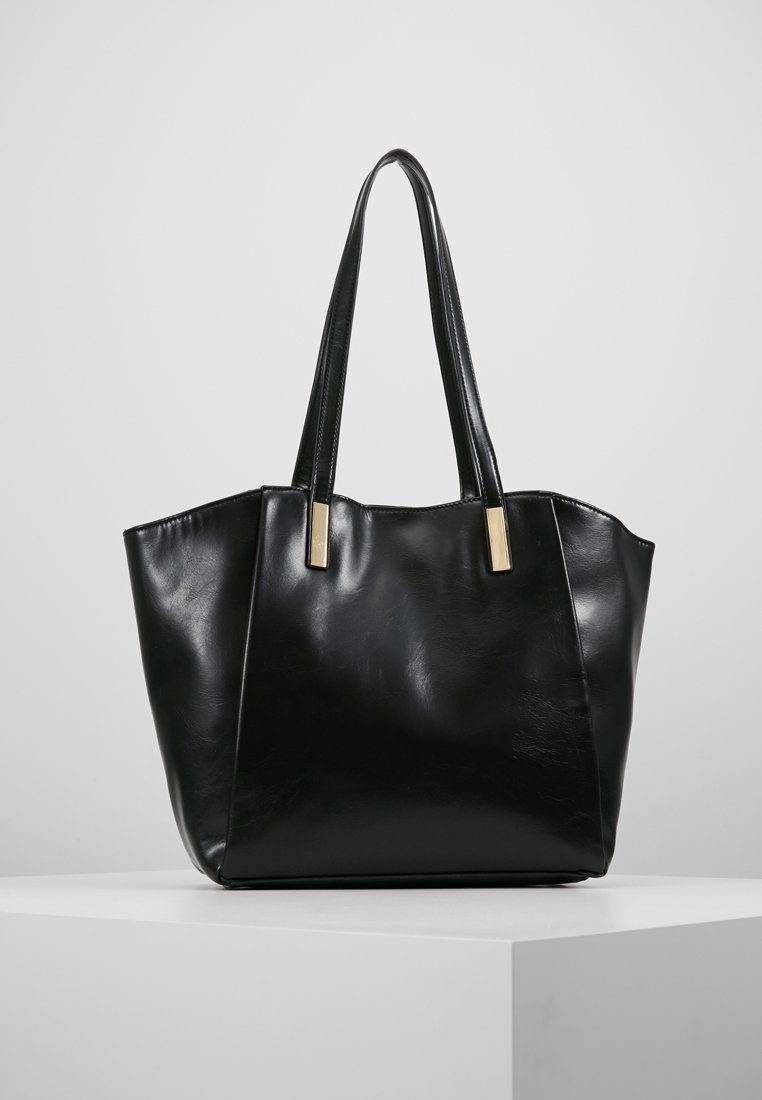 Black leather tote bag with a sleek, structured shape. Features long handles and gold-tone hardware accents. Smooth texture, no patterns.