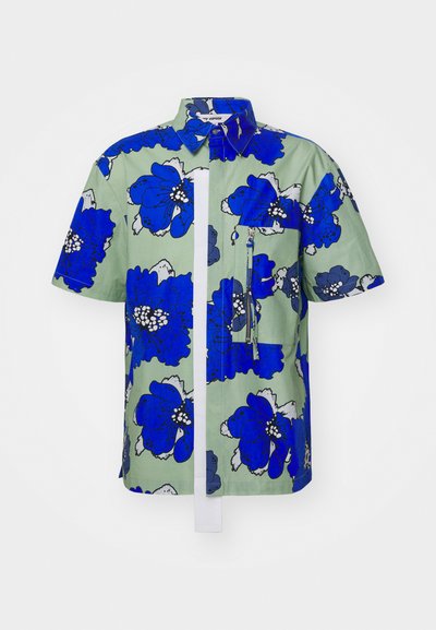 Camicia a maniche corte in tessuto verde con un motivo floreale blu, dotata di un pannello verticale bianco, tasca con zip e colletto standard.