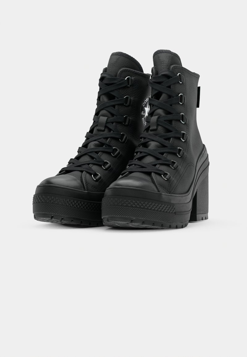 Bottes de cheville à plateforme noires en cuir texturé, avec un bout rond, un laçage sur le devant et un patch logo sur le côté. Talon bloc épais.