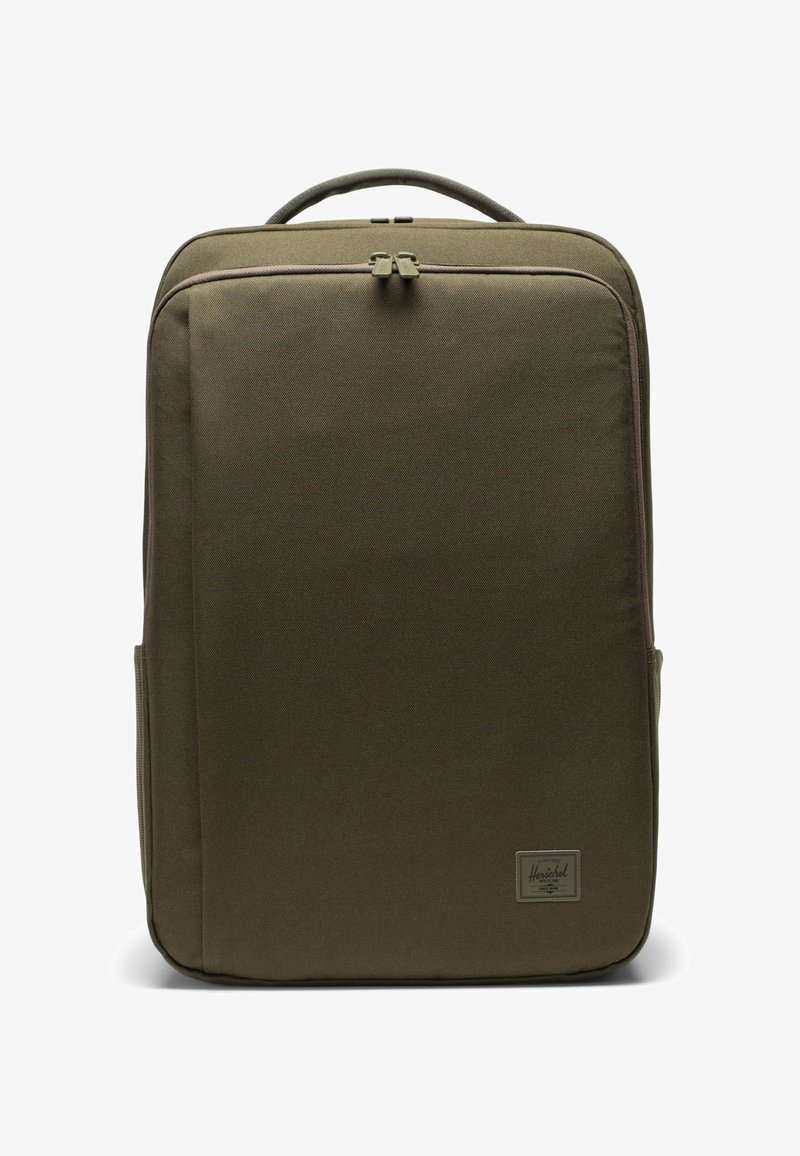 Plecak w oliwkowym zielonym kolorze wykonany z trwałej tkaniny, posiadający gładką powierzchnię, podwójne zamknięcie na zamek, wyściełaną rączkę oraz małą etykietę z logo marki z przodu.