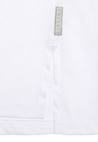 Weißes Baumwoll-T-Shirt mit Seitenschlitzdetail, ausgestattet mit einem eingenähten Etikett mit der Aufschrift "ELBSAND", glatte Textur und schlichtes, elegantes Design.