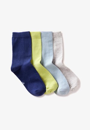 Vier hoge sokken in marineblauw, lichtgroen, lichtblauw en gemêleerd grijs liggen plat naast elkaar op een witte achtergrond.