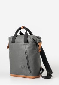 Grijze waterdichte tas met zwarte schouderbanden, leren accenten, een met rits afsluitbare voorzak en een gestructureerde bodem. Kenmerkt een logo aan de zijkant.
