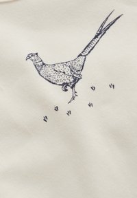 Katoenen stof met een crèmekleurige achtergrond kenmerkt zich door een gedetailleerde, donkerblauwe illustratie van een vogel met bijbehorende voetafdrukken.