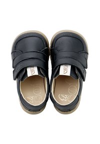 Zapatos de cuero negro con dos correas ajustables de Velcro, punta redonda, suela de goma beige y sutilezas en la costura en los lados.