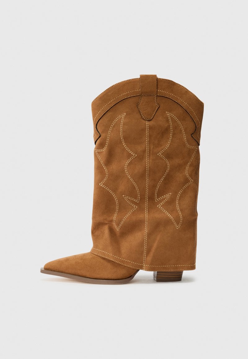 Pruun nubukist päitsed, millel on terav varvas, dekoratiivne õmblus ning keskmise kõrgusega plokknakk. Toru peal on lääne stiilis muster.