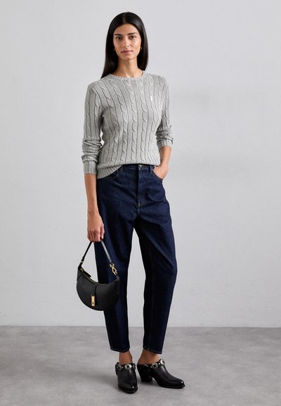 Light gray cable-knit sweater, dark blue high-waisted jeans, black handbag with gold accent, and black heeled shoes with decorative hardware.