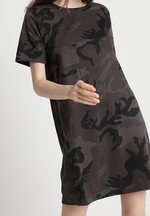 Kortærmet knælang kjole i mørkt camouflage mønster. Stoffet er blødt med en glat tekstur og indeholder sorte og mørkegrå nuancer.