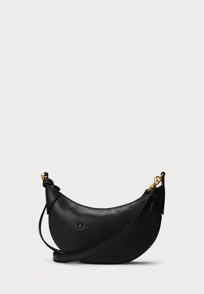 Črna usnjena torbica s ukrivljeno obliko, preproste zasnove, naramnico in zlatimi kovinskimi dodatki.