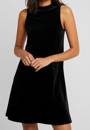 Czarna aksamitna sukienka z wysokim kołnierzem i bez rękawów. Gładka faktura, krój w literę A oraz długość do kolan.